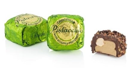 a small unwrapped chocolate next to two wrapped ones