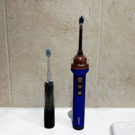 A Dyson electric toothbrush stands beside a smaller black Laifen toothbrush on a counter