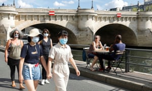 Pedestrians wearing protective face masks walk along the Seine river banks in Paris, as France reinforces mask-wearing as part of efforts to curb a resurgence of coronavirus.