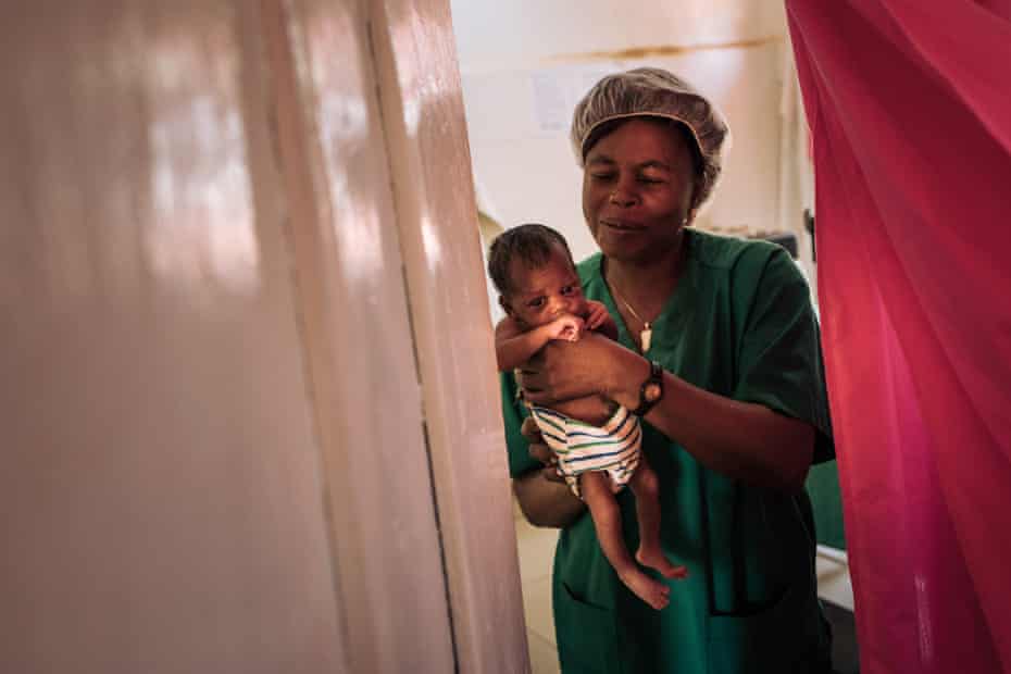 Laure, a midwife at Ndu health facility in Congo-Brazzaville, holds one of Ester’s baby twins delivered in the Democratic Republic of the Congo.