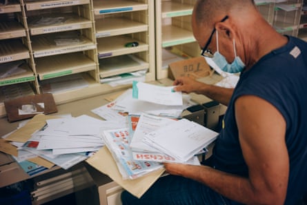 Cyril’s father, Yoland, helps to sort mail in the Salazie postal centre.