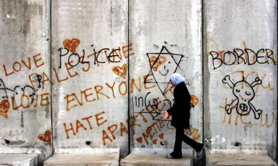 A Palestinian woman walks along a section of Israel’s controversial barrier by the West Bank town of Abu Dis, on the edge of Jerusalem, in 2005. 