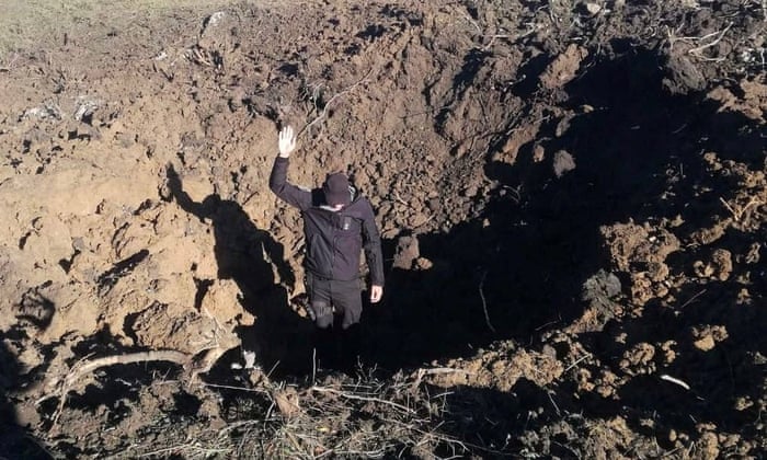 A police officer stands on a bottom of a shell crater left by a Russian military strike at a compound of the Pivdennoukrainsk nuclear power plant, amid Russia’s invasion of Ukraine, in Yuzhnoukrainsk, Mykolaiv region, Ukraine, in this handout picture released September 19, 2022. Press service of the National Nuclear Energy Generating Company Energoatom/Handout via REUTERS