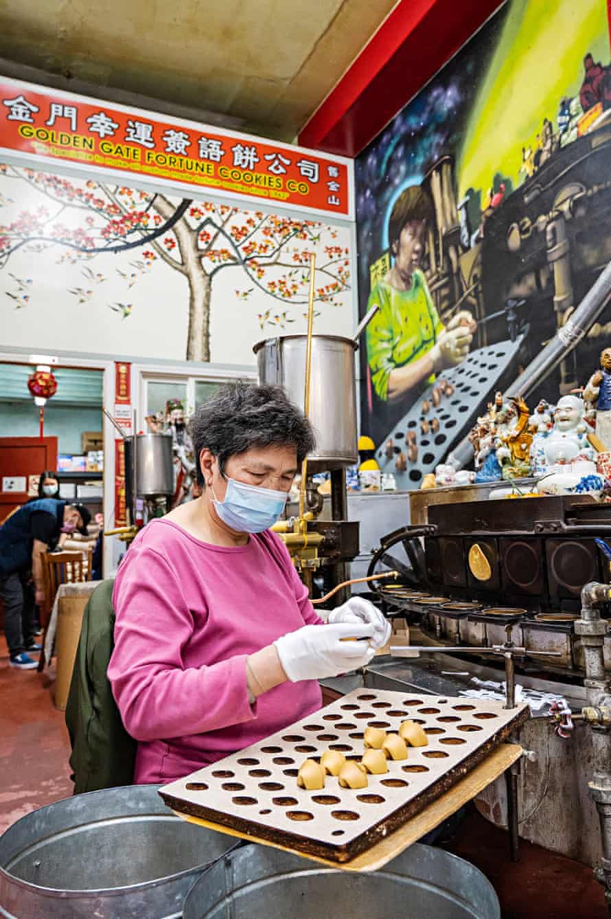 A worker makes fortune cookies at the Golden Gate Fortune Cookie Factory