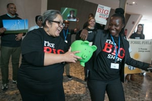 Representatives of The Big Shift Global protest against the financing of fossil fuels, offering delegates the chance to put chocolate coins into either a green piggy bank representing green energy, or a brown piggy bank representing fossil fuels.