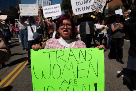 Celebrations and protests in the US and around the world mark International Women’s Day Person hold sign saying Trans Women are Women