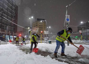 City workers clear snow from the road in Milan