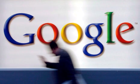 A man passes by a Google logo 