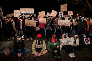 Protesters holding anti-PiS signs.