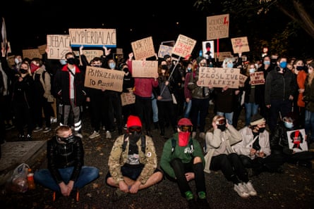 Protesters holding anti-PiS signs.