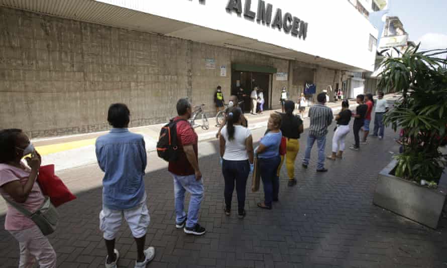 People line up at a supermarket to make purchases amid the coronavirus pandemic, in Panama City, Panama, 23 March 2020.
