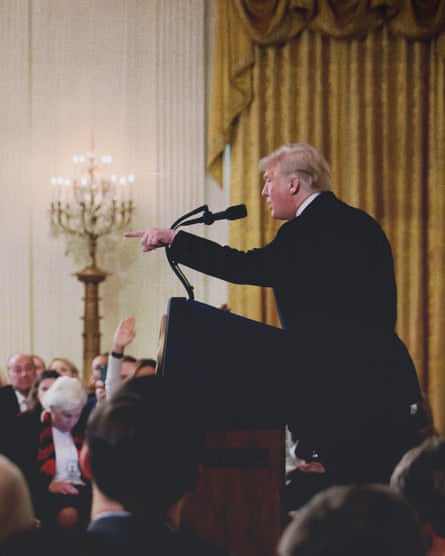 a man speaks into a microphone as another man points at him