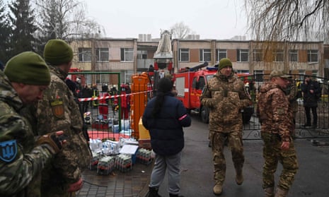 Militares y rescatistas trabajan cerca del lugar donde se estrelló un helicóptero en las afueras de la capital, Kyiv.