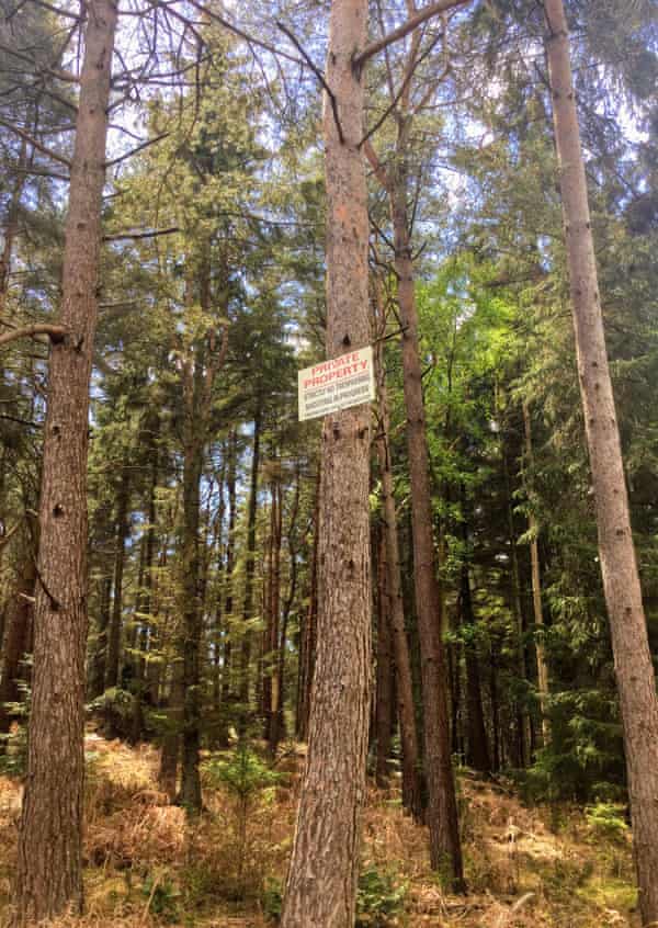 A sign in a wooded estate warns people to keep out.