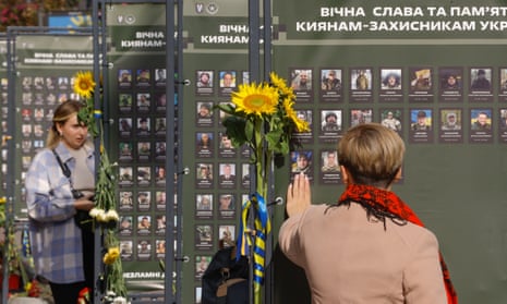 People look at images of Kyiv residents who died during the war with Russia.