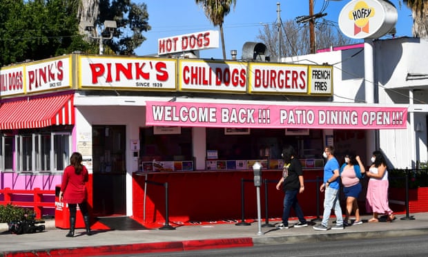People make their way to Pink’s Hot Dogs on the reopening day of the iconic Los Angeles restaurant on 1 March 2021 in California.