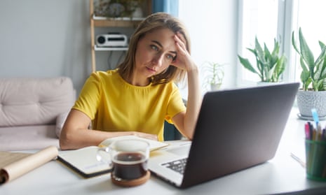 A young woman looking stressed as she works from home.