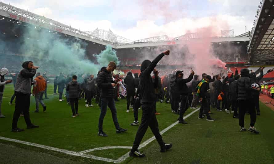 Manchester United supporters on the Old Trafford pitch.