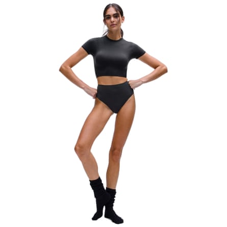 A person wearing a Wundermost ultra-soft Nulu high-waist thong. They are wearing a black crop top and their hands are on their hips.