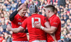 Josh Adams, scorer of Wales’s first try against Scotland, and Liam Williams congratulate Jonathan Davies on crossing for the second