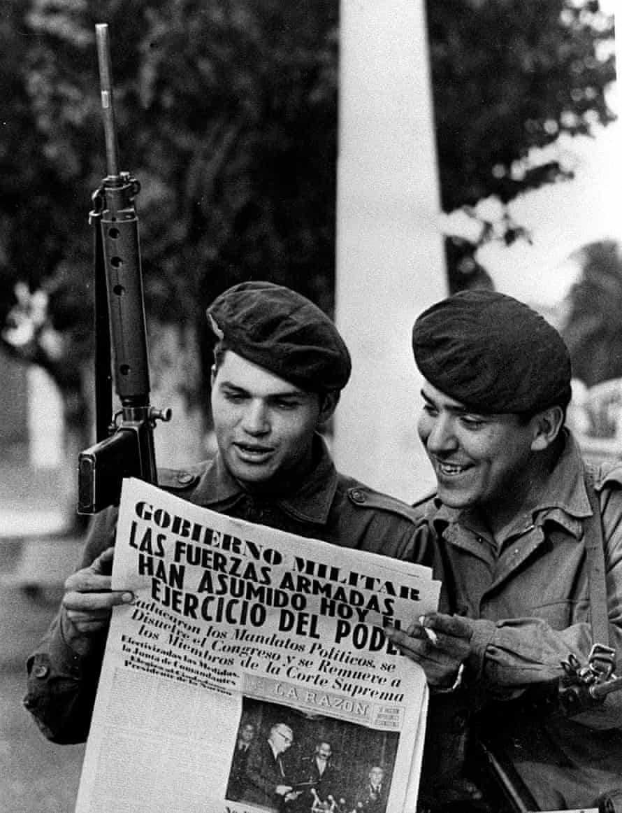 Soldiers read a newspaper in the Buenos Aires Plaza de Mayo after a military coup, 24 March 1976