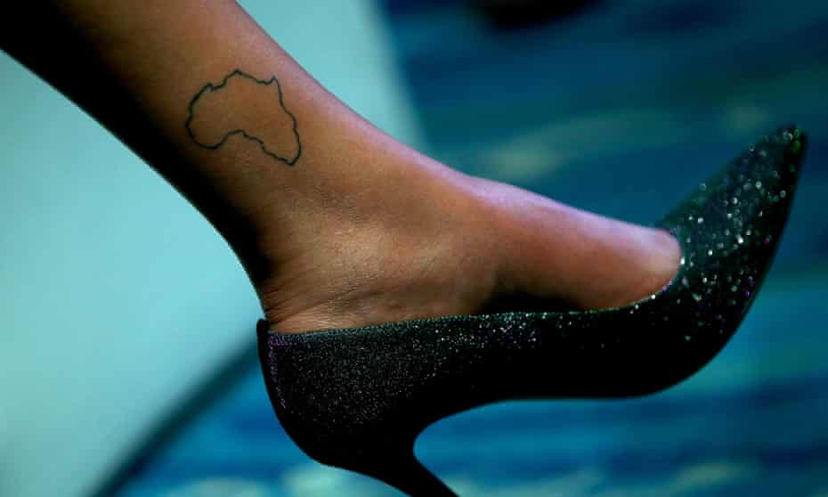 A map of Africa is seen tattooed on the ankle of a woman wearing stiletto heels