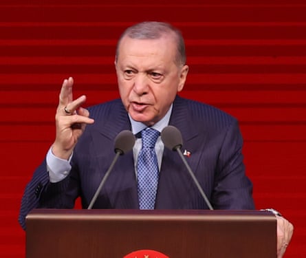 Recep Tayyip Erdoğan delivers a speech in front of a red background