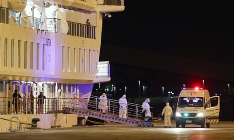 A passenger infected with the new coronavirus disembarks from the Australian cruise ship Greg Mortimer in Montevideo, Uruguay