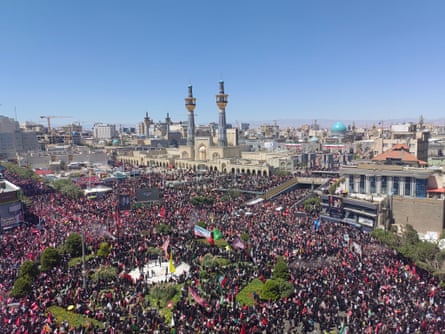 Aerial view of crowds of people in an area outside a large mosque