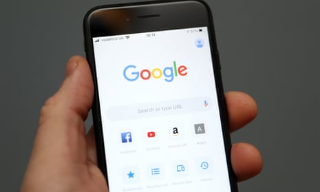 A person holds an iPhone showing the app for Google Chrome search engine