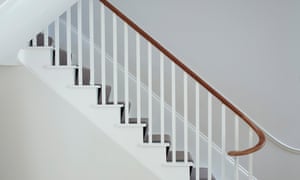 White painted stairwell, lit by skylights.