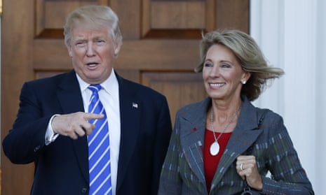 President-elect Donald Trump calls out to the media as he and Betsy DeVos pose for photographs at Trump national golf club in Bedminster, New Jersey.