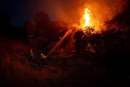 a firefighter sprays water at a blaze