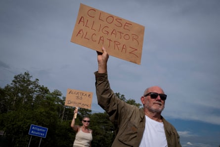 People hold signs that read ‘Close alligator Alcatraz’ and ‘Alcatraz is inhumane’