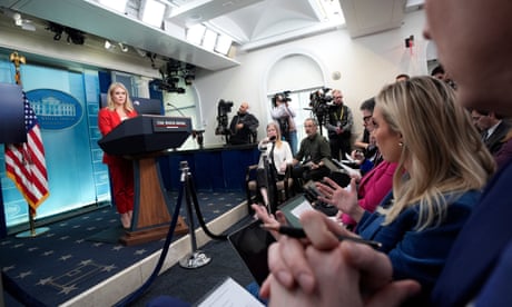 people sitting in a room look at a woman speaking at a podium