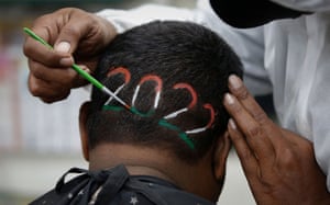 Ahmedabad, India. A barber colours the 2022 digits shaved into a man’s hair at a barbershop.