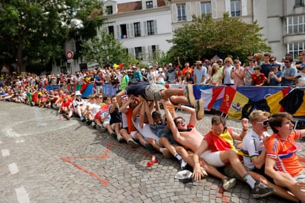 Spectators near the top of Montmartre partake in strange games on the course as they wait for the race to arrive during the men’s cycling road race on day eight of the Paris 2024 Olympics.