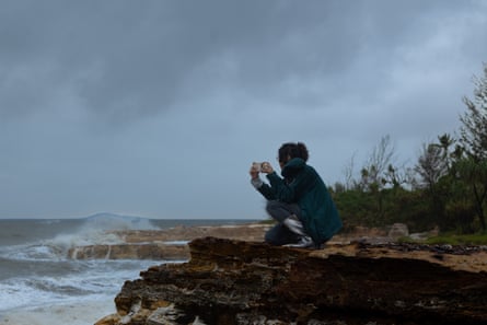 Person takes photo of ocean from cliff top