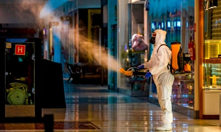 An employee wearing protective gear disinfects a shopping mall in Caxias do Sul, Brazil, on 13 May.