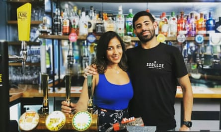Megha and Gaurav Khanna standing behind the bar at the Gladstone Arms