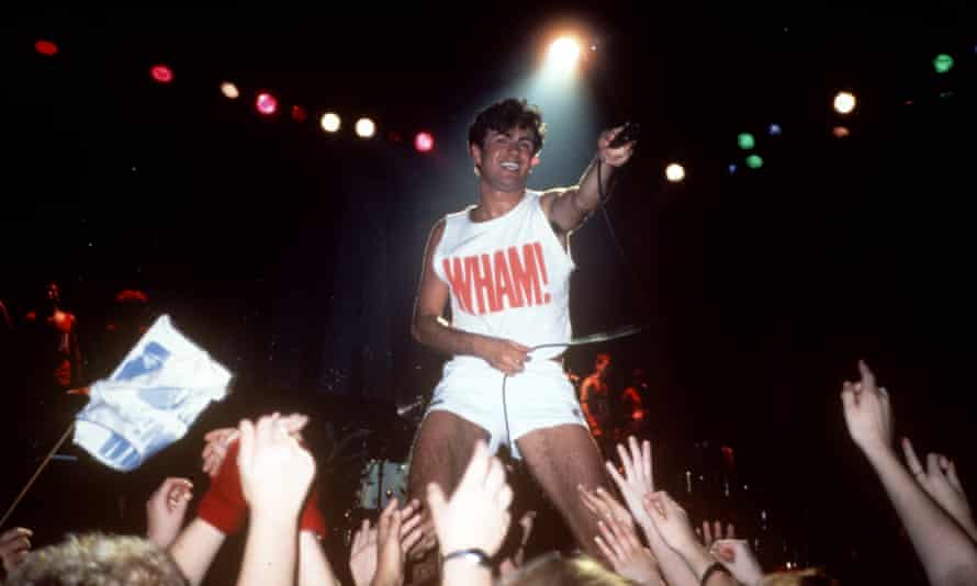 Michael performing with Wham! in short white shorts and crop top