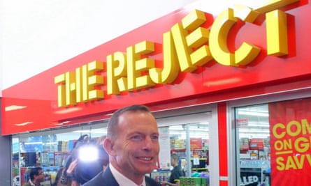 Tony Abbott passes by an unfortunately named shop at Kippax, Canberra in June 2015.