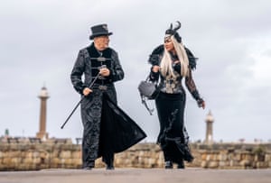 A goth couple walk along the seafront