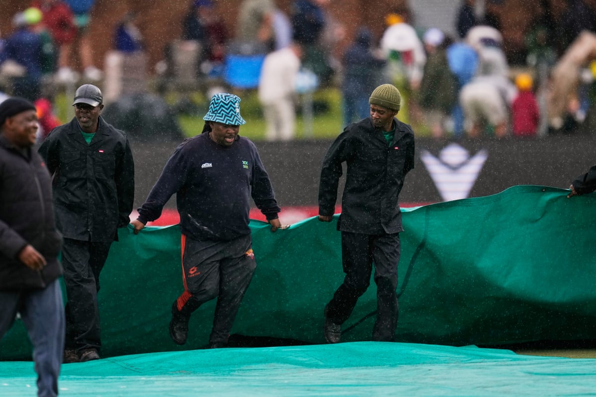 Groundstaff cover the pitch