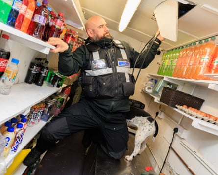 A police officer searching a shop in Greater Manchester during a previous raid