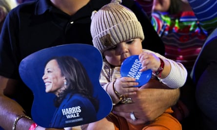 A baby plays with a Harris-Walz pin at a rally for Kamala Harris in Reno, Nevada.