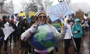 Amy Guerrieri, of Fort Collins, Colorado, wears a home-made model of earth and participates in a climate change awareness march and rally, in Denver.