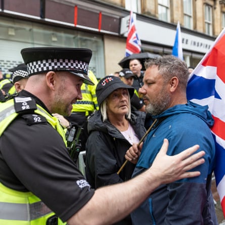Policeman talks to a man holding a flag