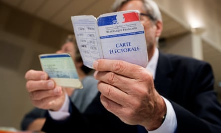 An assessor verifies the identity of a voter in the first round of the French presidential elections in Tulle