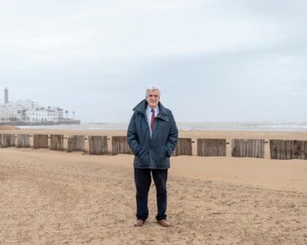 A man in a coat on a beach